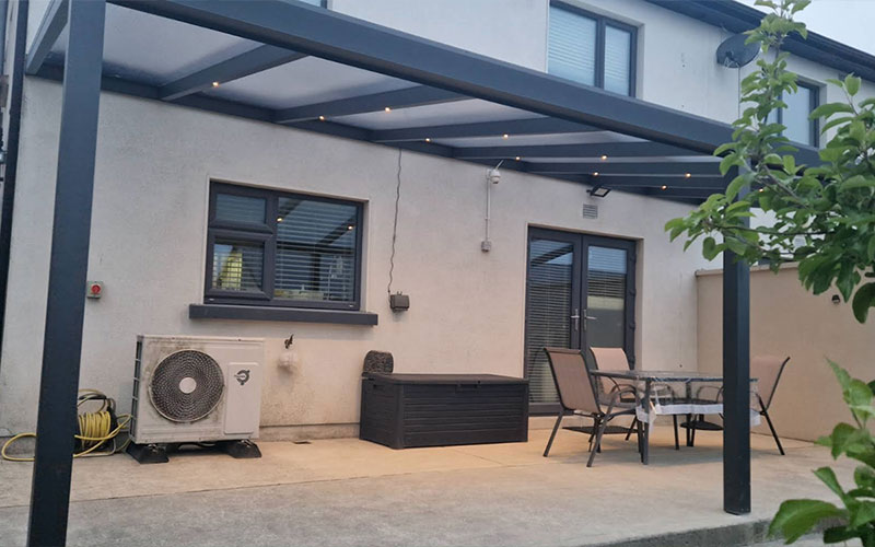 Aluminium pergola with a clear polycarbonate roof and recessed warm LED lighting