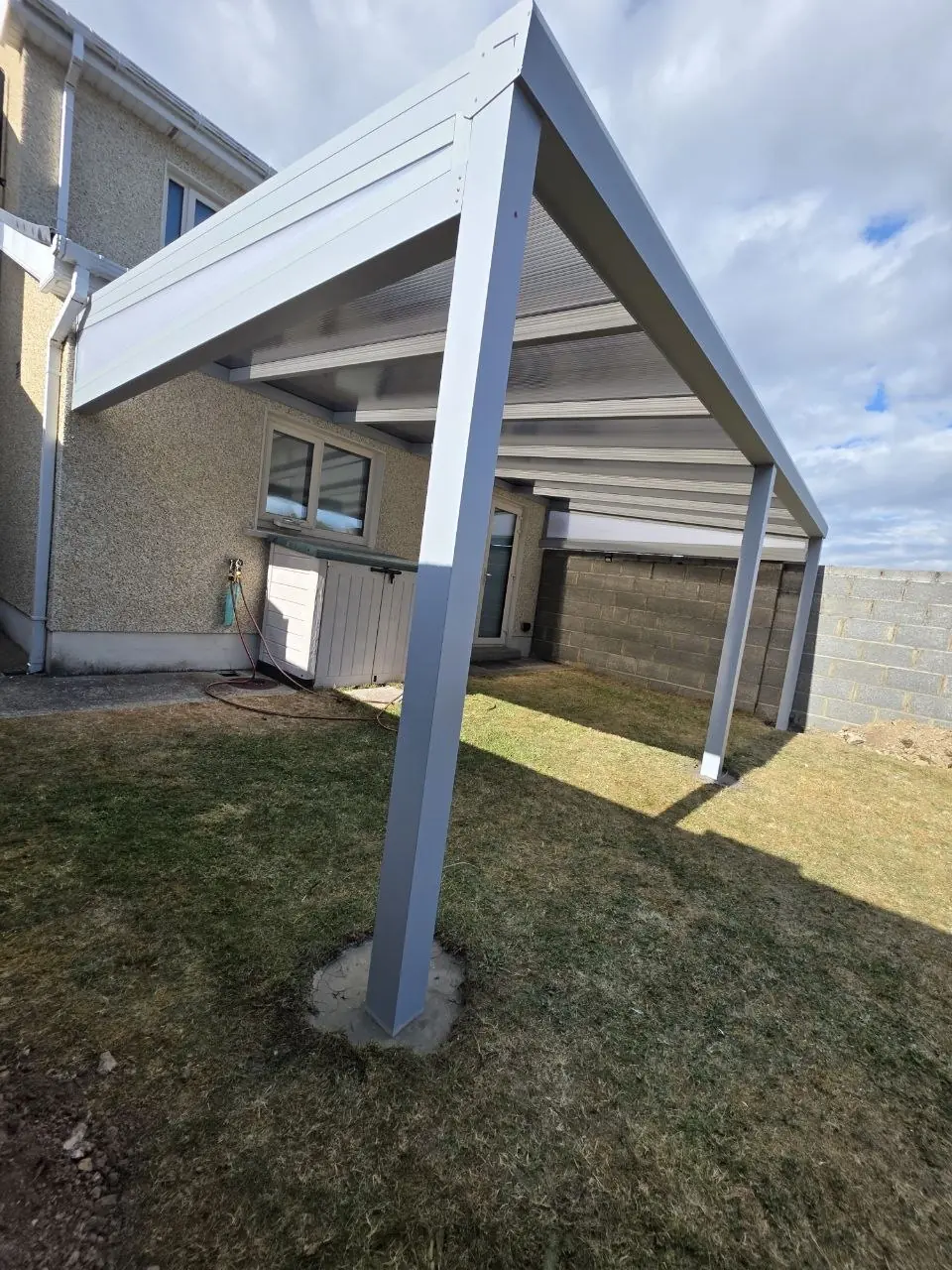 Wall-mounted pergola with a silver-grey frame and triangular side infill