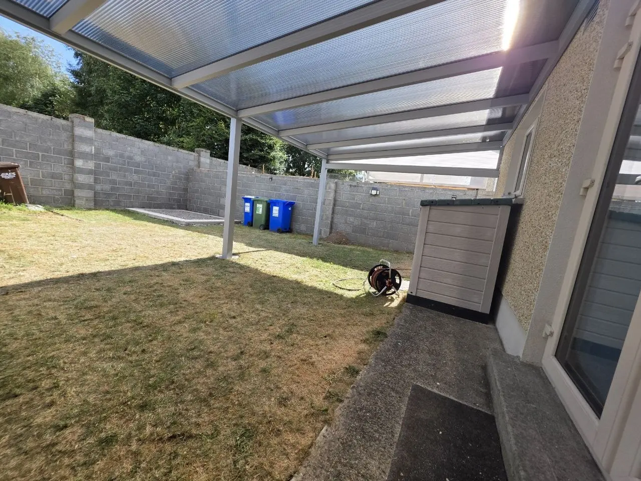 View from beneath the clear polycarbonate roof across the covered garden