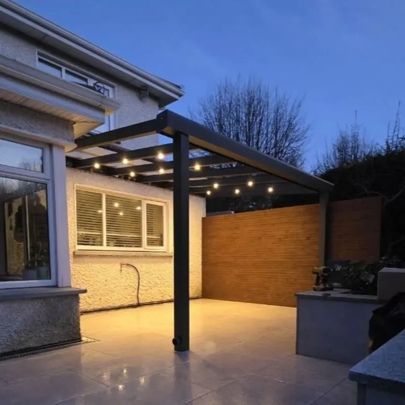 Wall-mounted aluminium pergola with a glass roof and integrated lighting