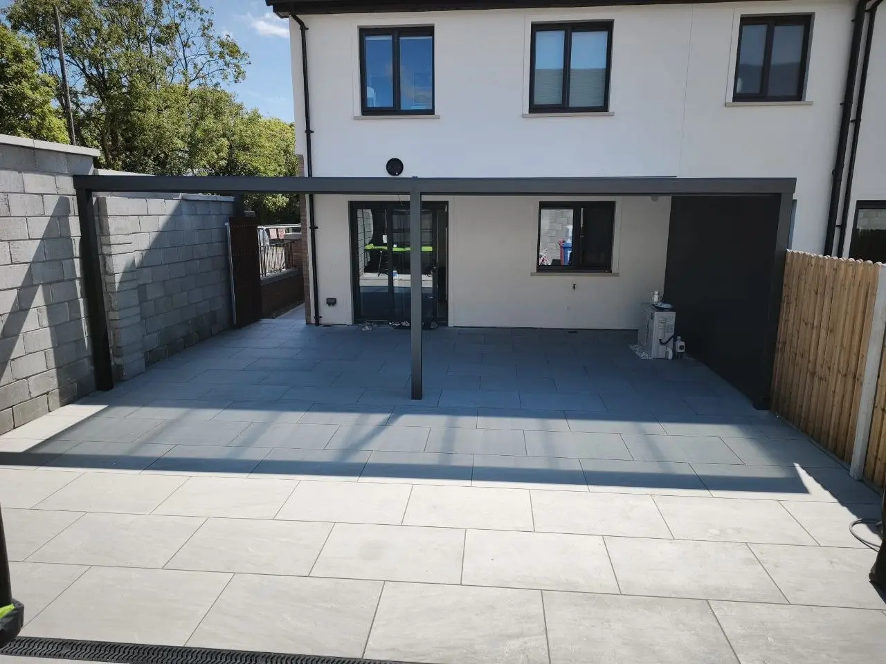 Completed wall-mounted aluminium pergola with a polycarbonate roof in Cork
