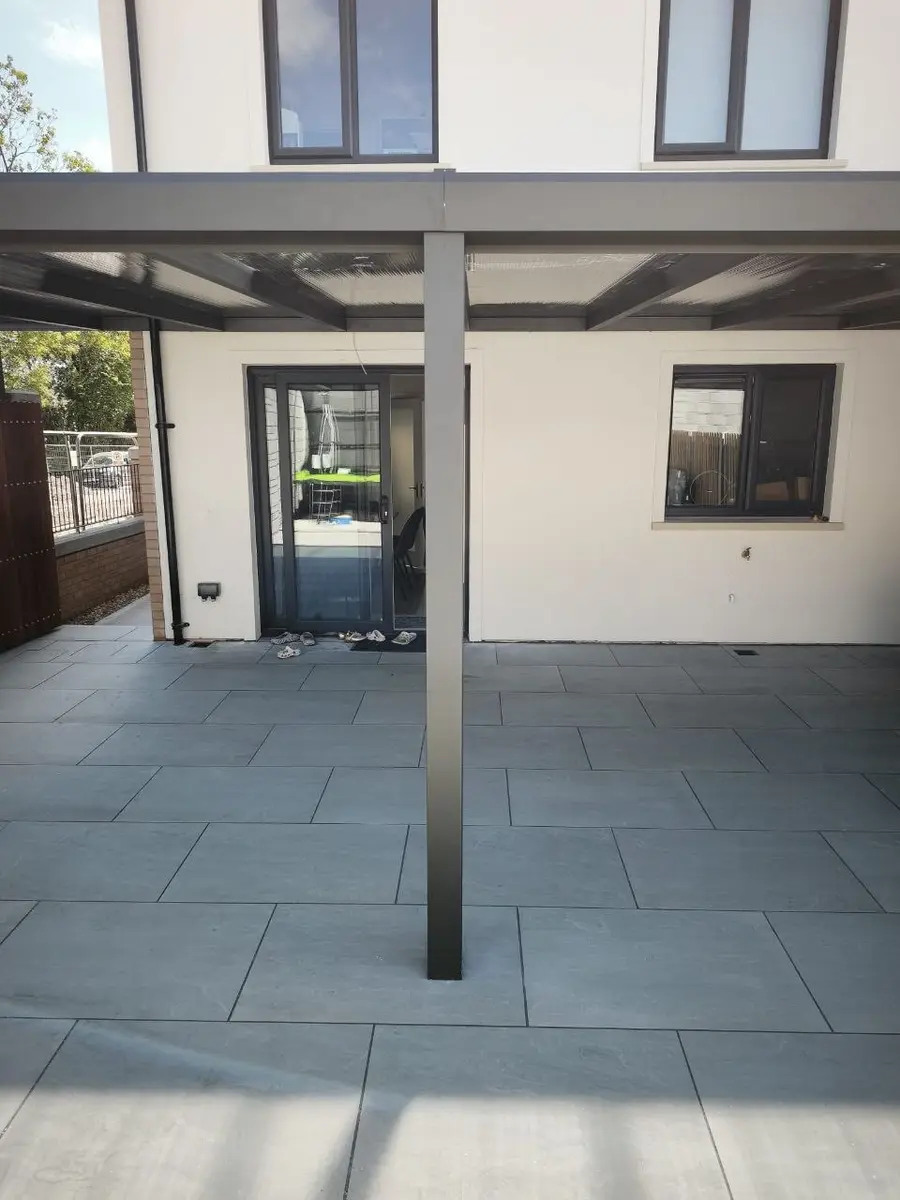 Covered patio beneath a wall-mounted polycarbonate pergola in Cork