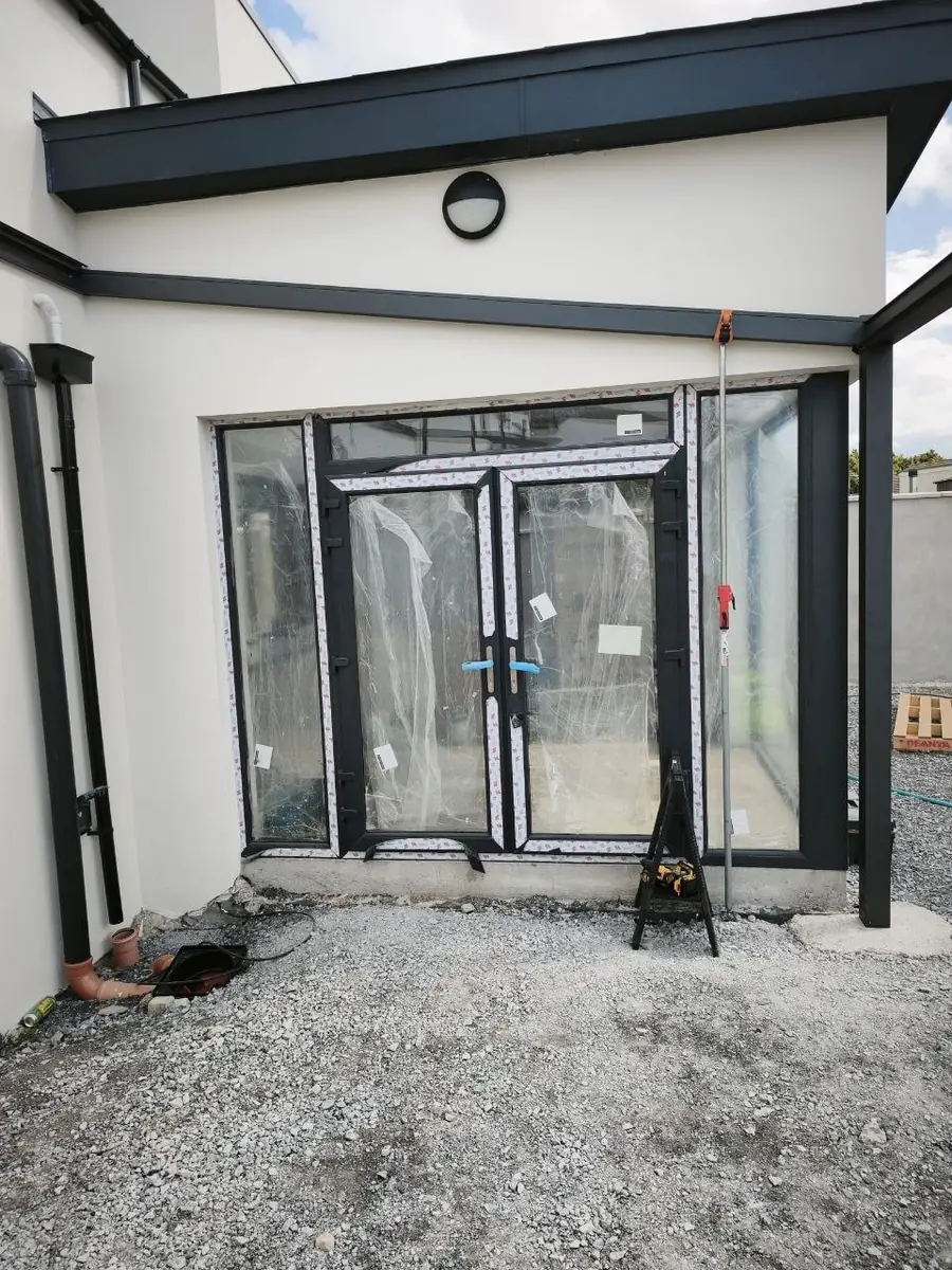 Wall connection beside the rear doors during pergola installation in Ennis