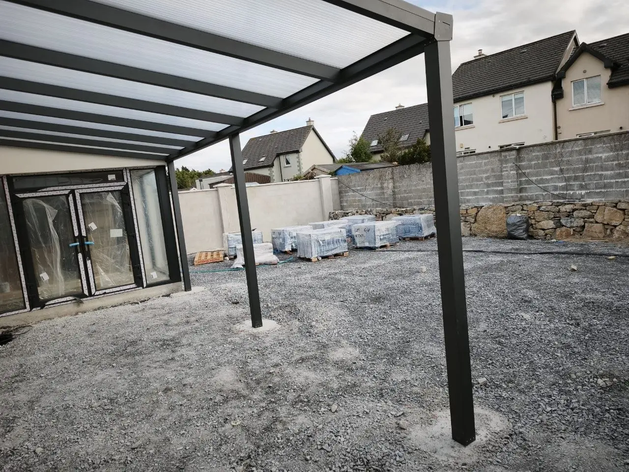 Clear polycarbonate roof over a wall-mounted aluminium pergola in Ennis