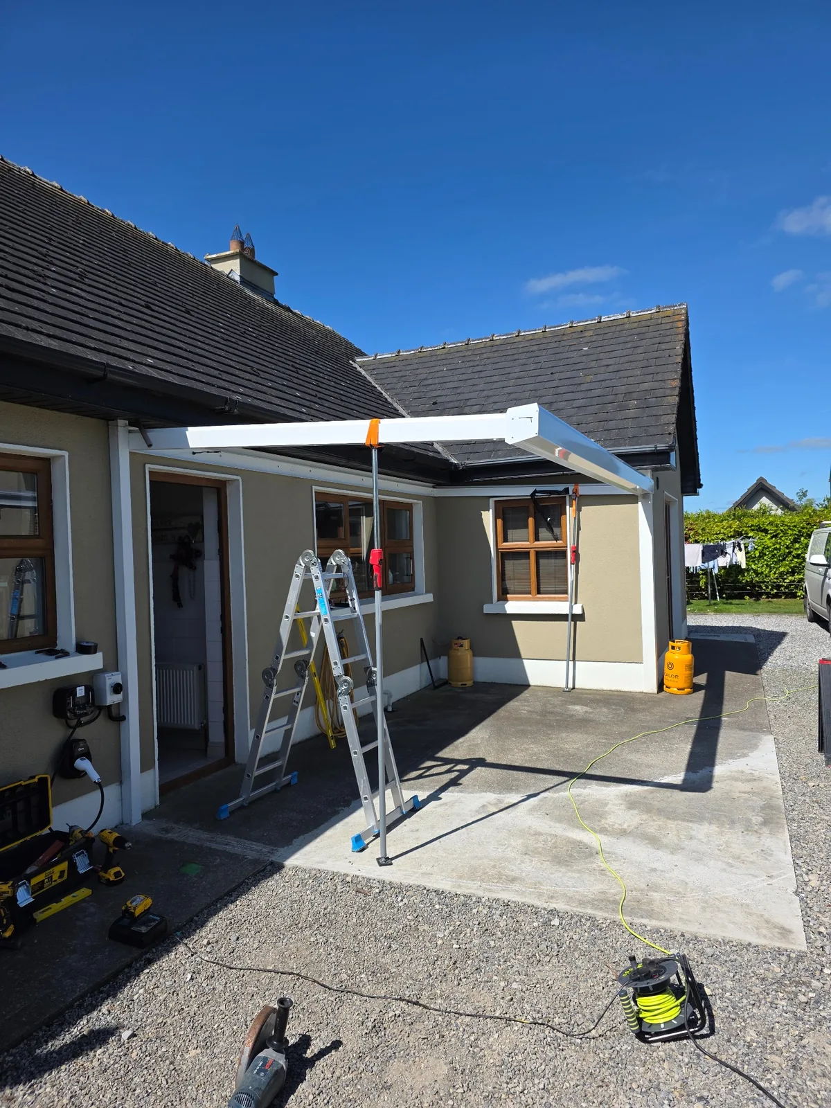 White aluminium garden room frame being installed beside a home in Roscommon