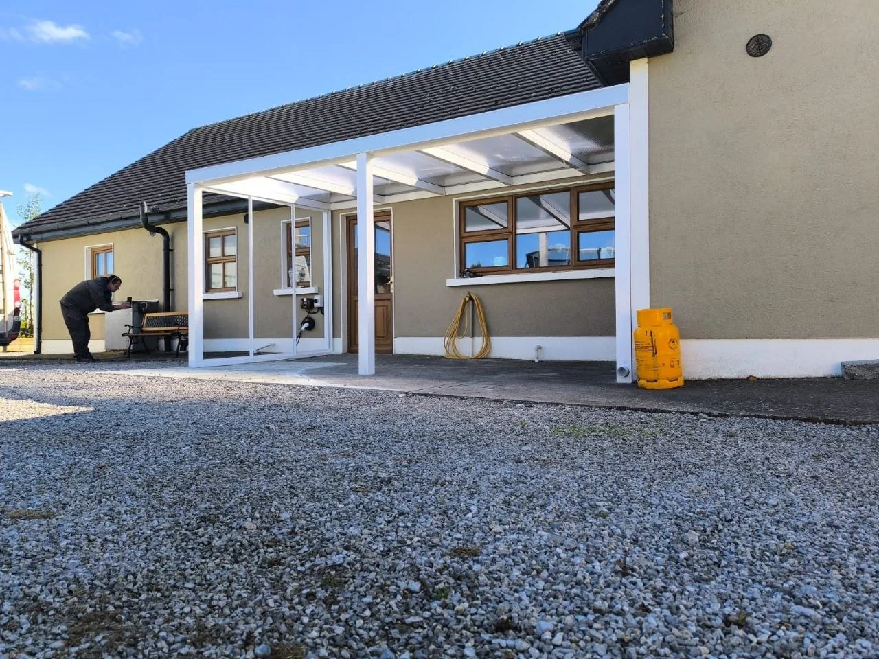 White aluminium garden room frame with milk polycarbonate roof during installation in Roscommon