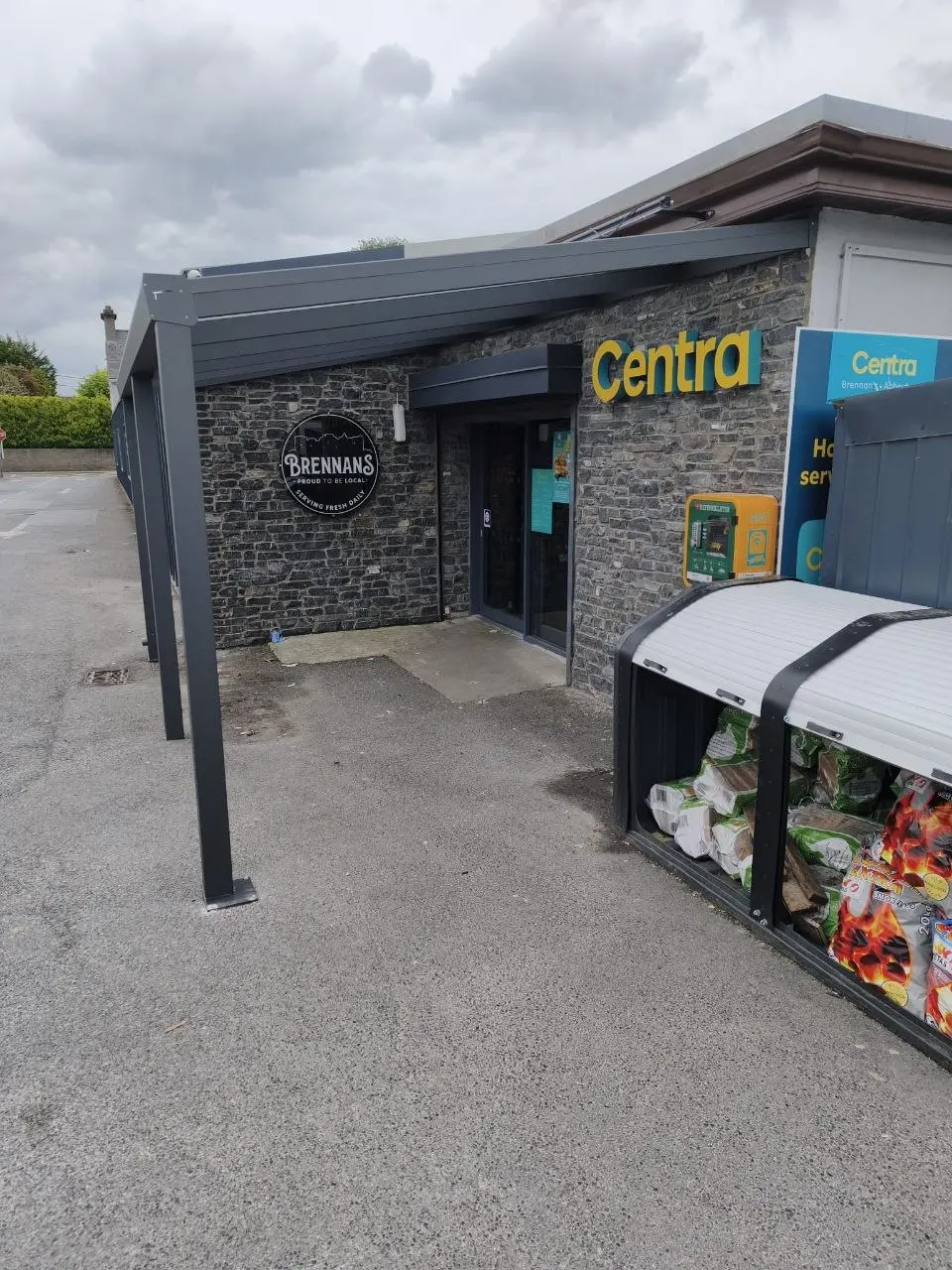 Long side view of the wall-mounted canopy and support posts at Centra Roscommon
