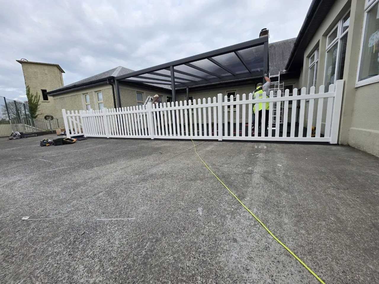 Side view of the made-to-measure aluminium canopy being installed inside the school courtyard