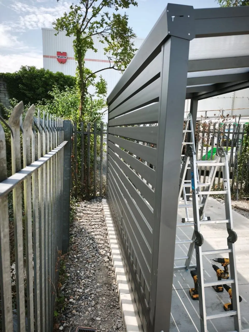 Horizontal aluminium side wall being installed on the Würth smoking shelter
