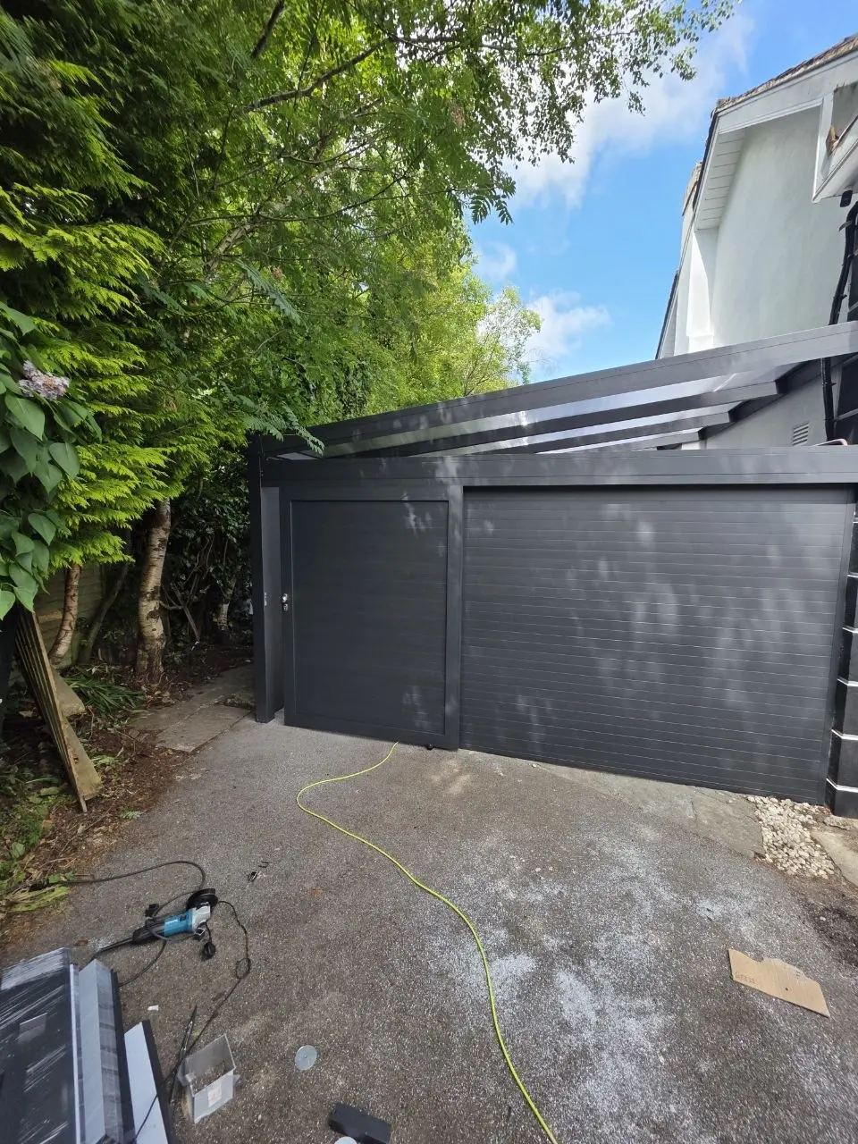 Front view of the manual garage door and separate pedestrian door on the Kilbride carport