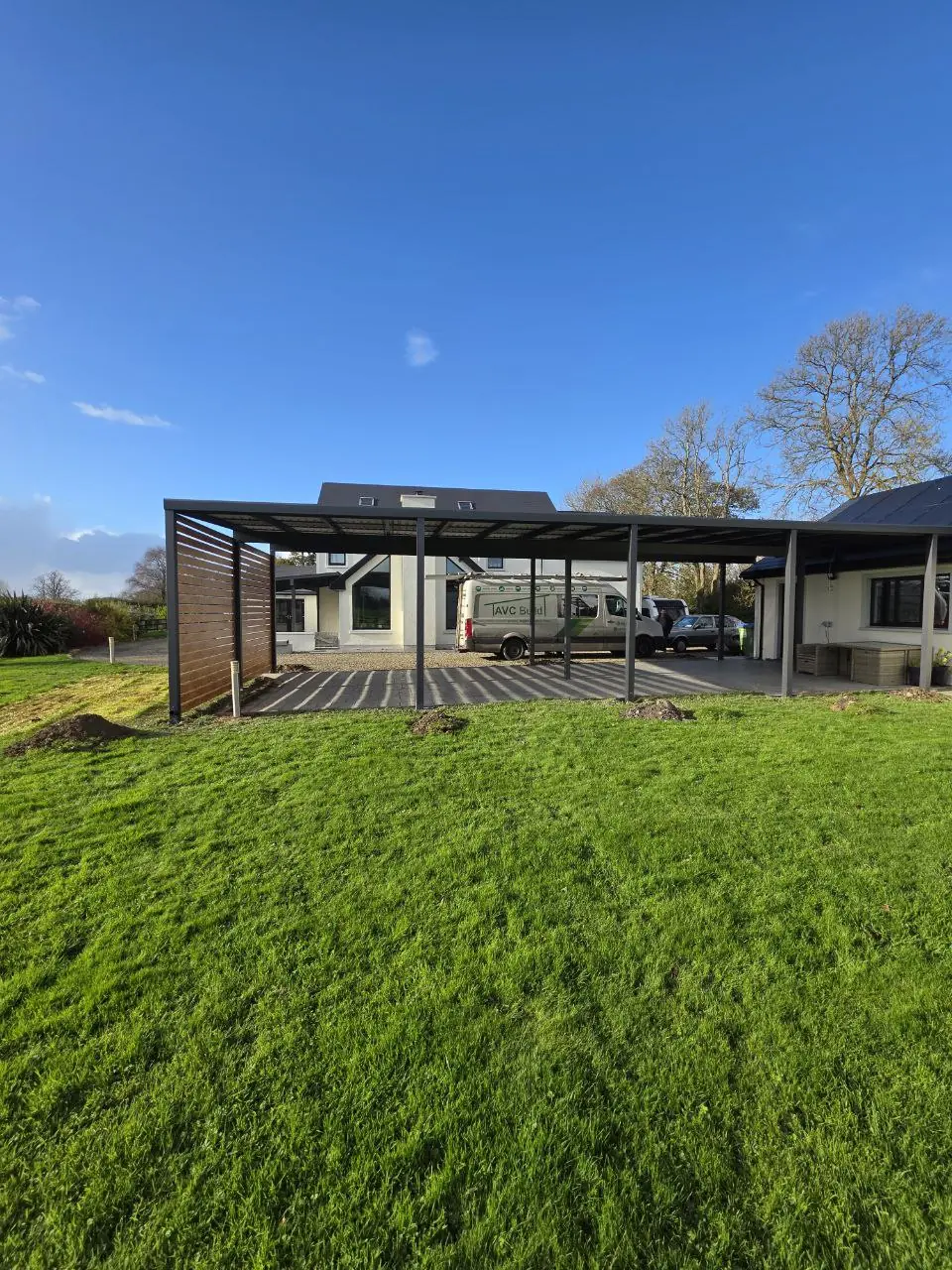Completed four-car aluminium carport viewed from the garden in Sixmilebridge
