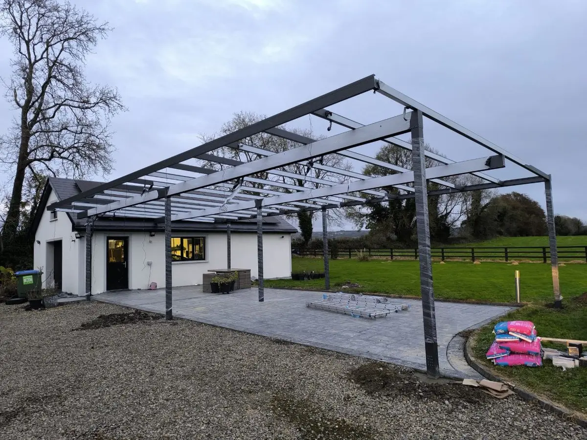 Wide view of the large black aluminium carport frame during installation