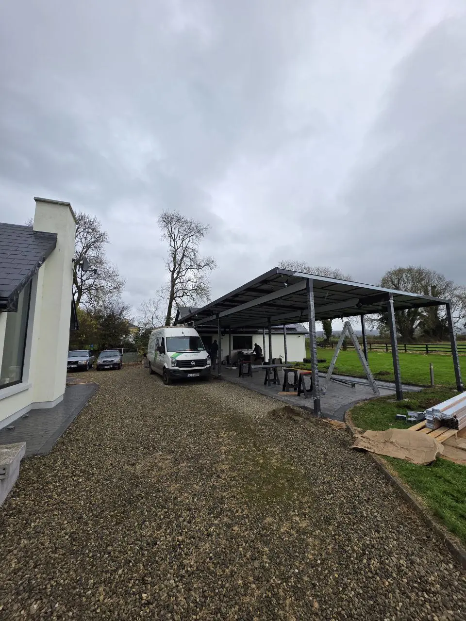 Trapezoidal sheet roof installation progressing across the large aluminium structure