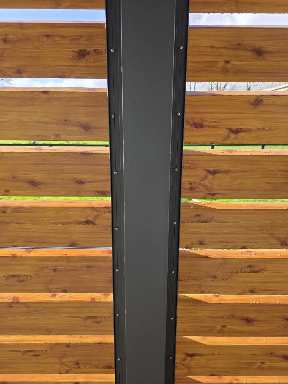 Close-up of the wood-effect Diamond-shaped side wall and black aluminium post