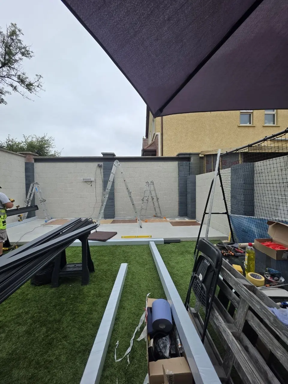 Rear-garden patio area during preparation for the wall-mounted aluminium canopy in Limerick