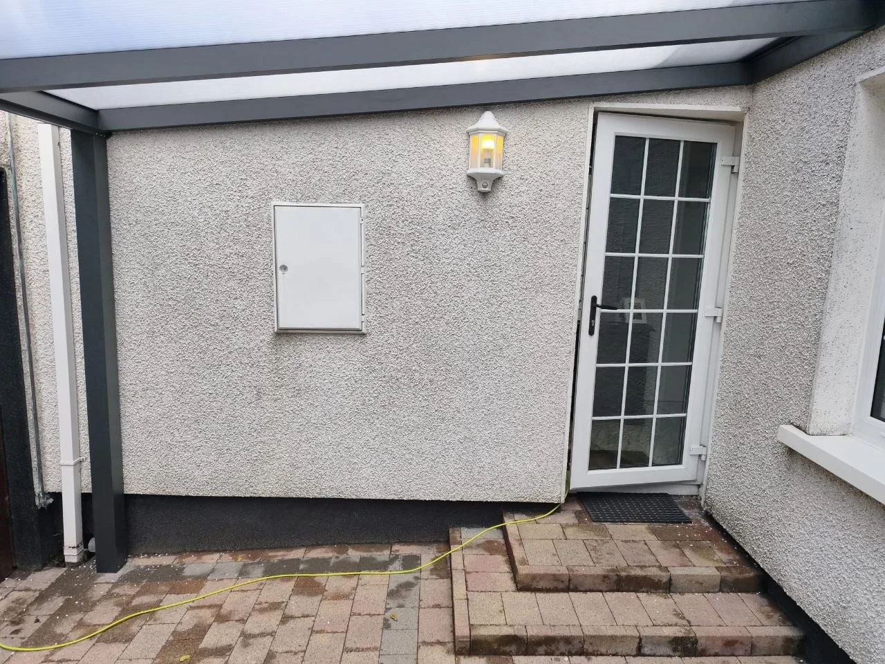 Covered courtyard beside the existing residential doors beneath the aluminium canopy in Dublin