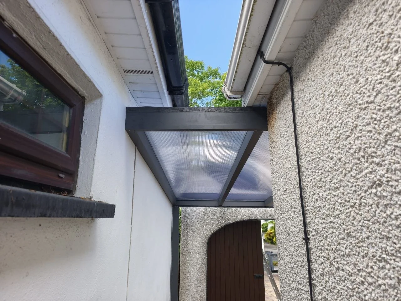 Polycarbonate roof connection detail between the aluminium canopy and existing courtyard walls