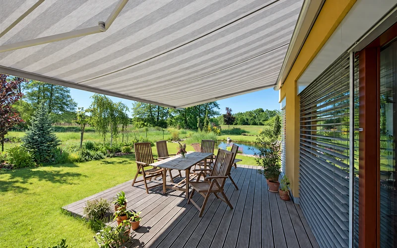 Striped retractable patio awning above an outdoor dining area