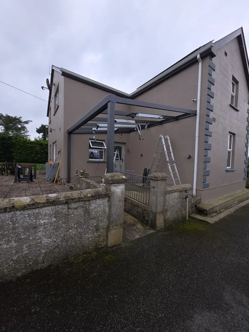 Wall-mounted aluminium canopy frame during installation in Cavan