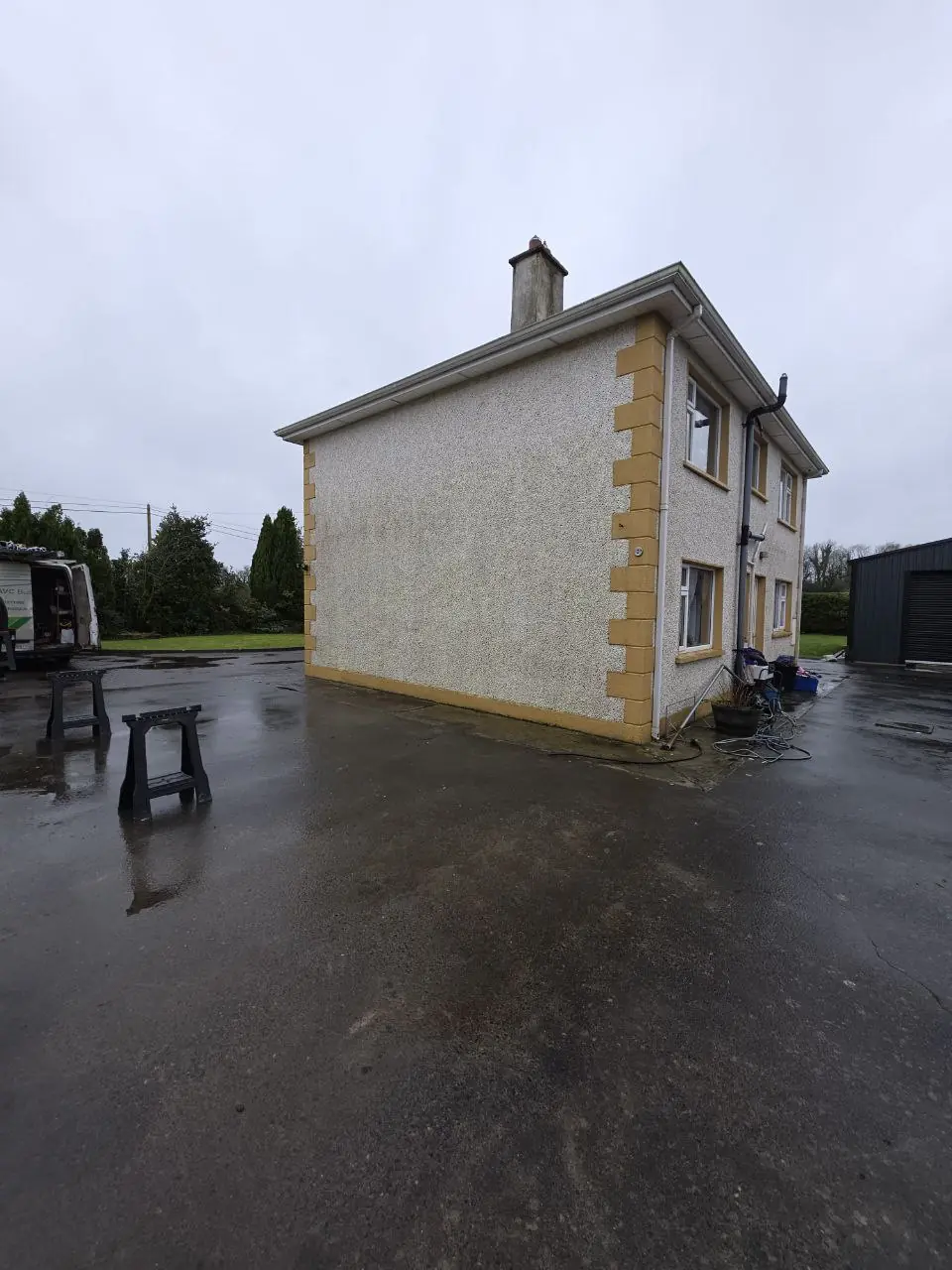 Prepared driveway and house wall before carport installation in Cavan