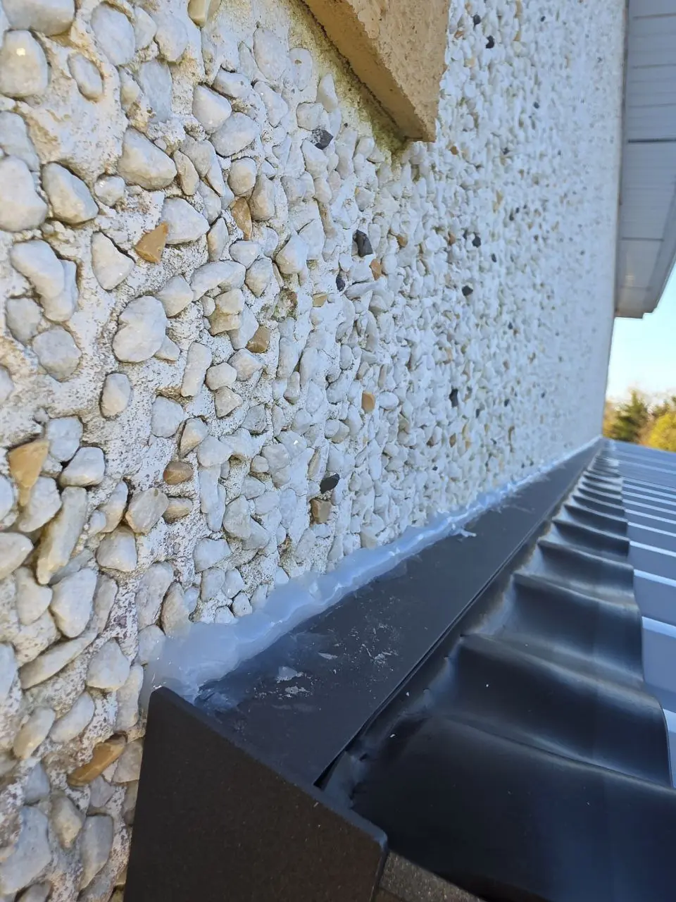 Weather-sealed connection between the carport roof and house wall