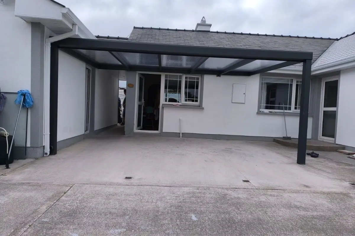 Black wall-mounted aluminium patio canopy at a residential property in County Leitrim
