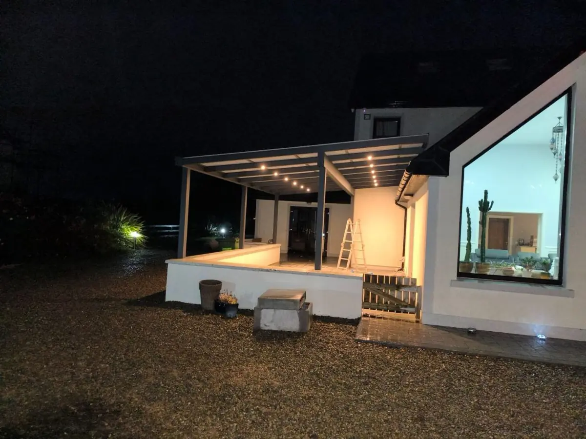 Wall-mounted pergola illuminated by integrated LED lights at night