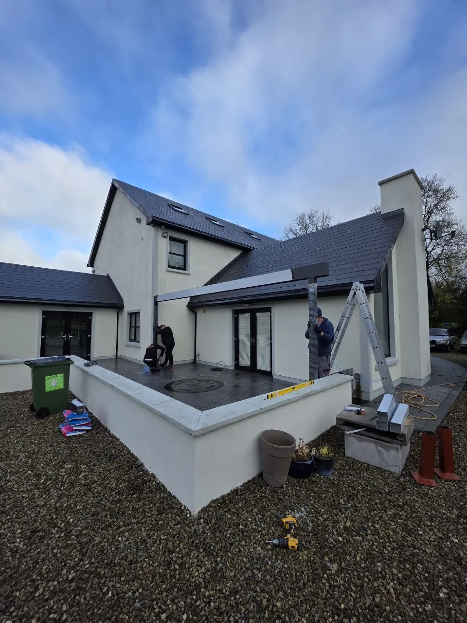 Pergola support posts being positioned across the raised terrace and existing walls