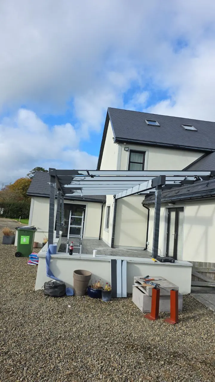 Trapezoidal roof support system during installation of the wall-mounted pergola