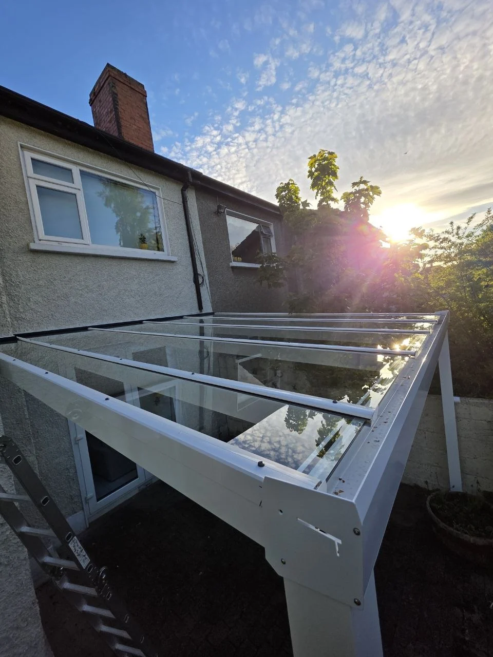 Glass roof detail on the white wall-mounted pergola completed in Dublin