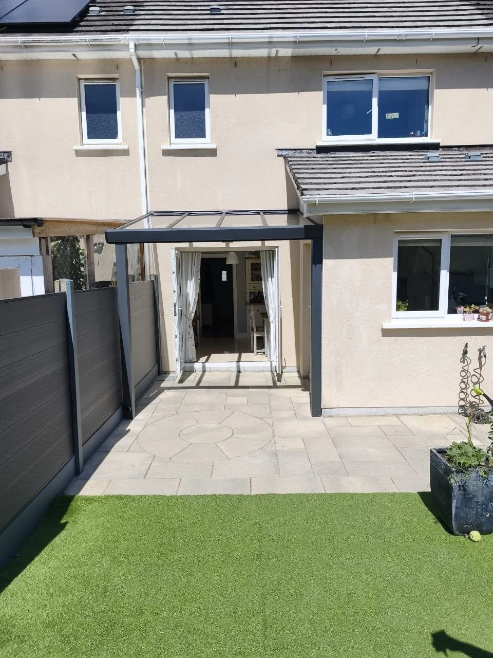 Black wall-mounted glass entrance canopy installed at the rear of a residential property in Dublin