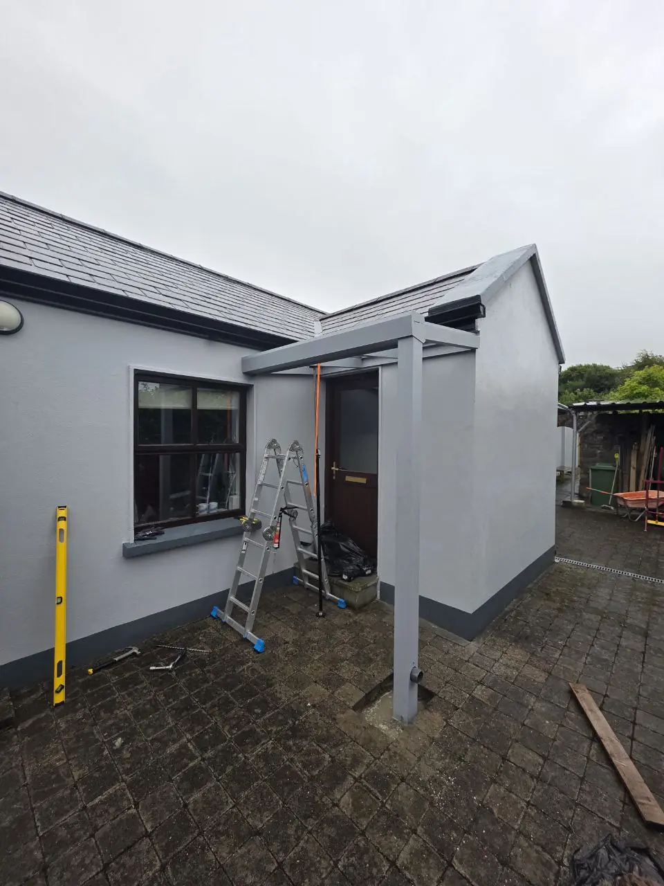 Grey wall-mounted canopy frame during installation at the residential property in Westport