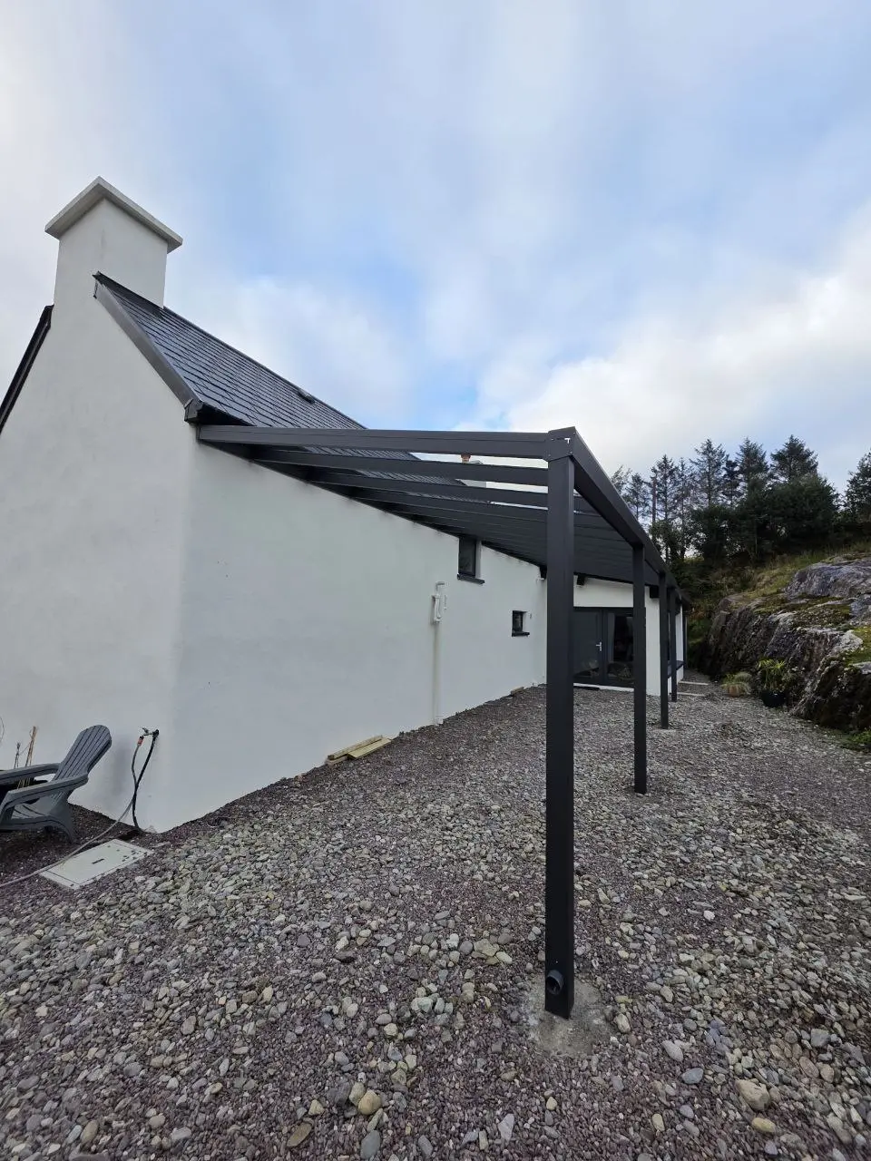 Long black aluminium pergola frame installed beside the house in Bantry