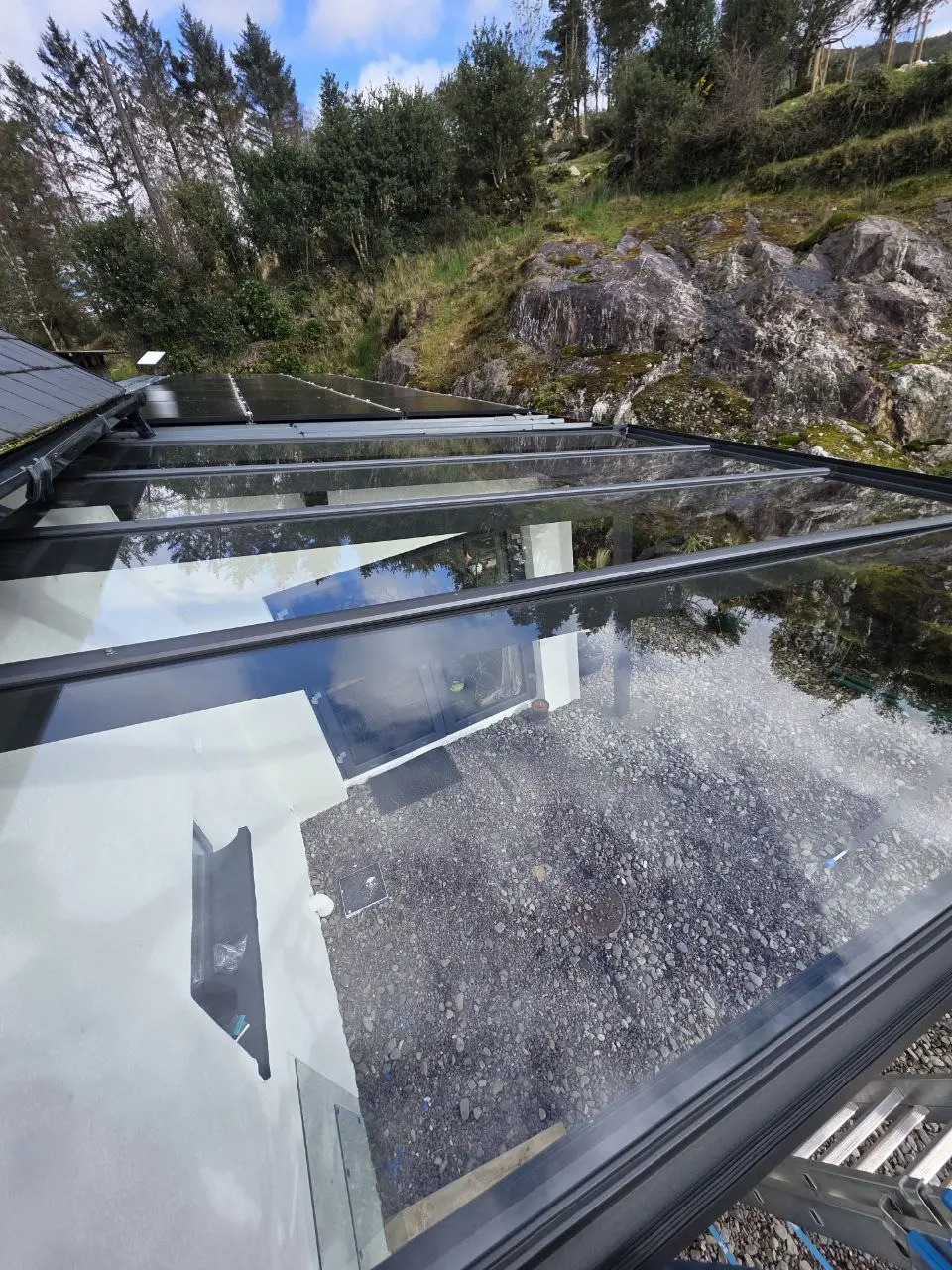 Close view of large glass roof panels and black aluminium glazing bars
