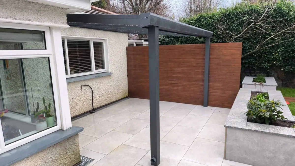 Completed black aluminium pergola covering the rear patio in Greystones
