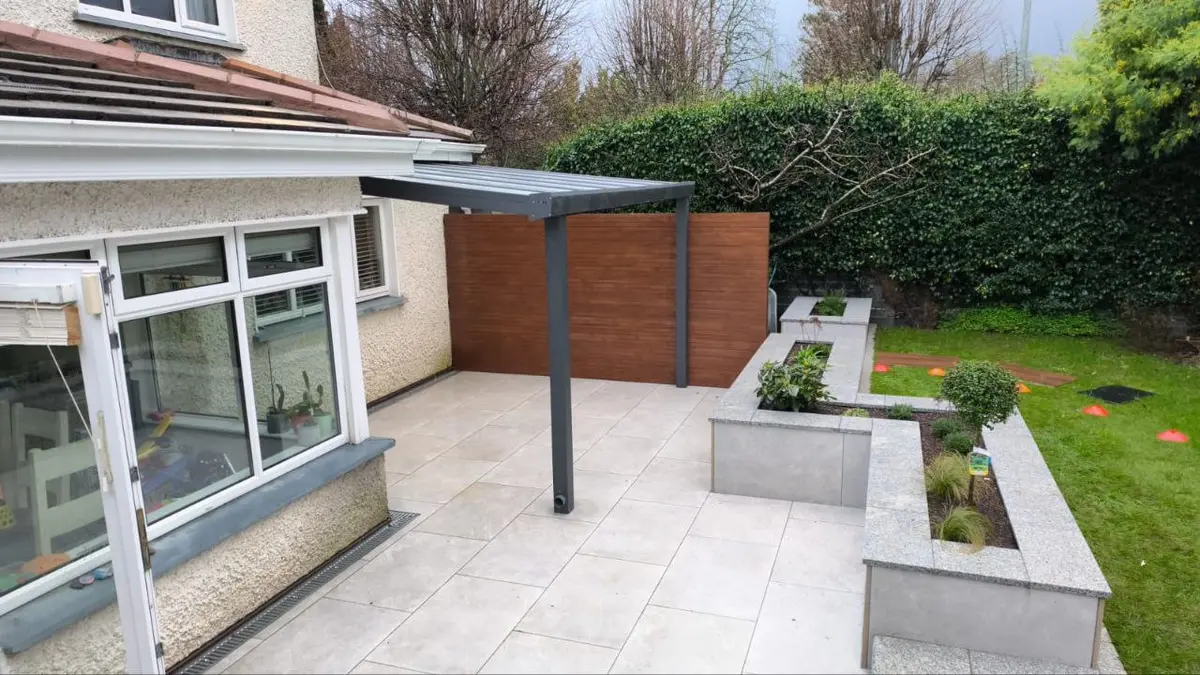 Garden view of the completed wall-mounted polycarbonate pergola
