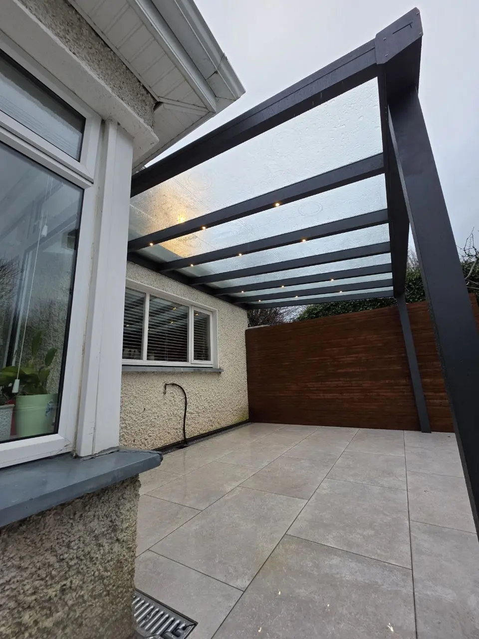 Polycarbonate roof and integrated LED lights viewed from beneath the pergola