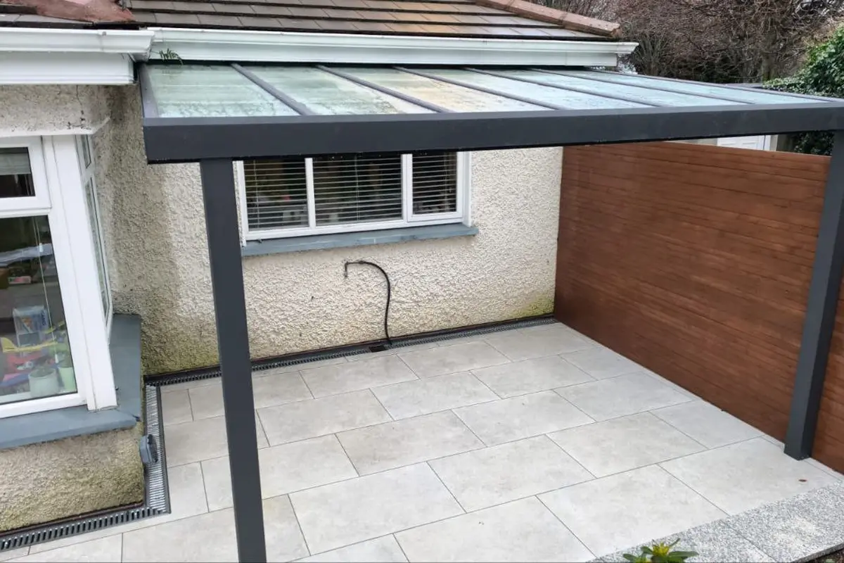 Black wall-mounted aluminium pergola with a polycarbonate roof in Greystones, County Wicklow