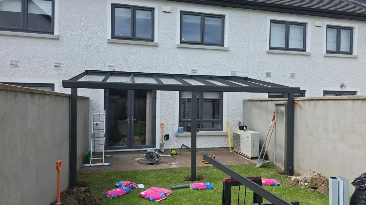 Front view of the wall-mounted aluminium pergola frame during installation