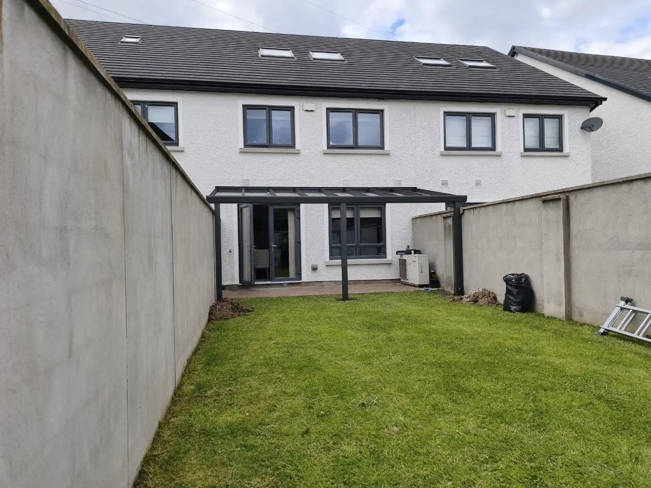 Wide garden view of the pergola frame installed between existing boundary walls