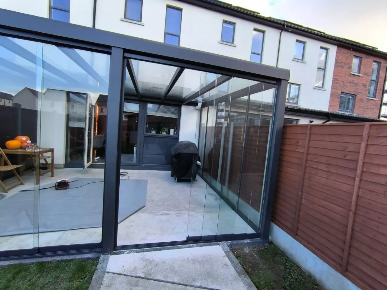 Completed wall-mounted glass pergola viewed from the side of the Dublin garden