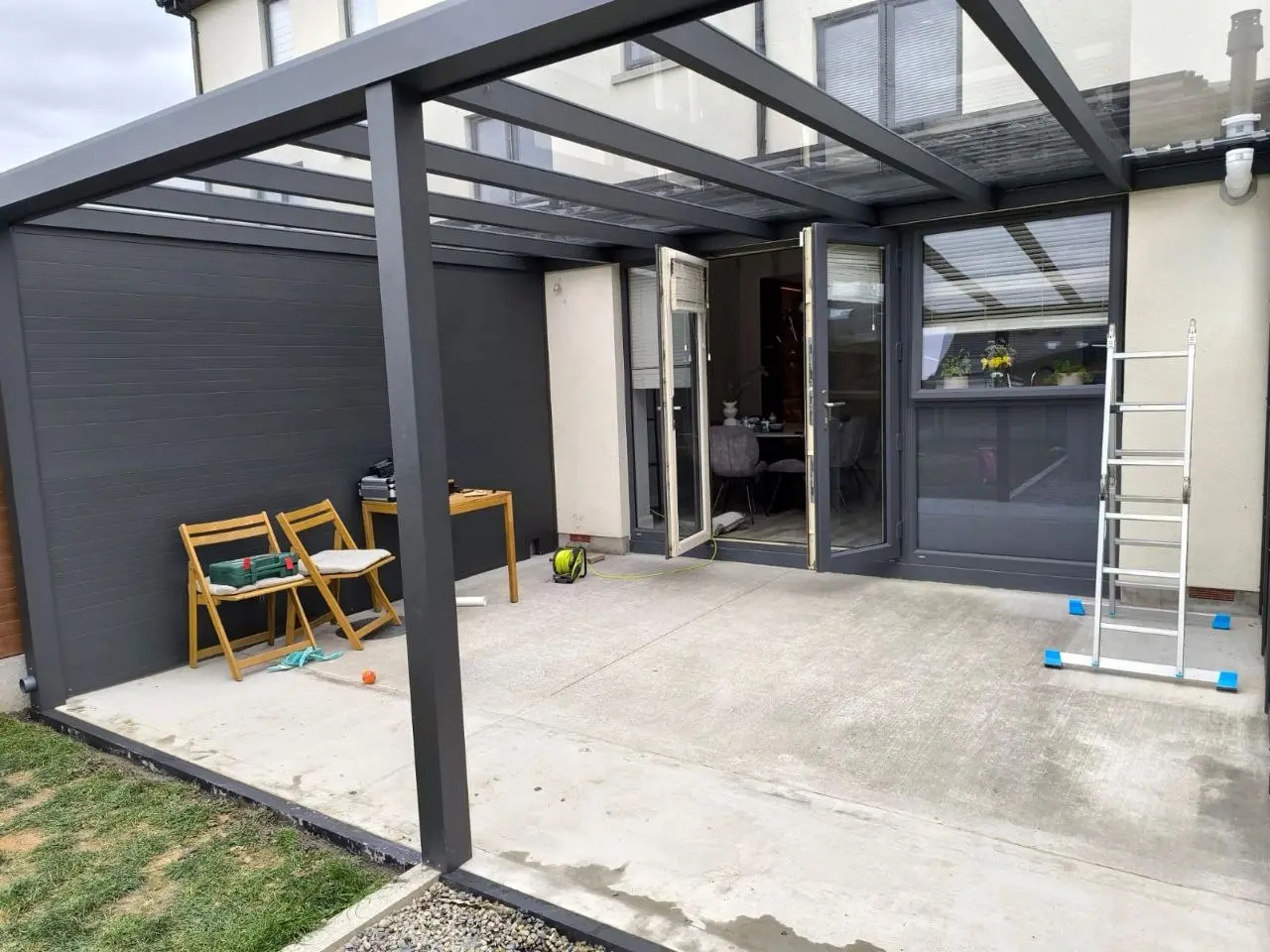 Safety glass roof being installed on the black aluminium pergola in Dublin
