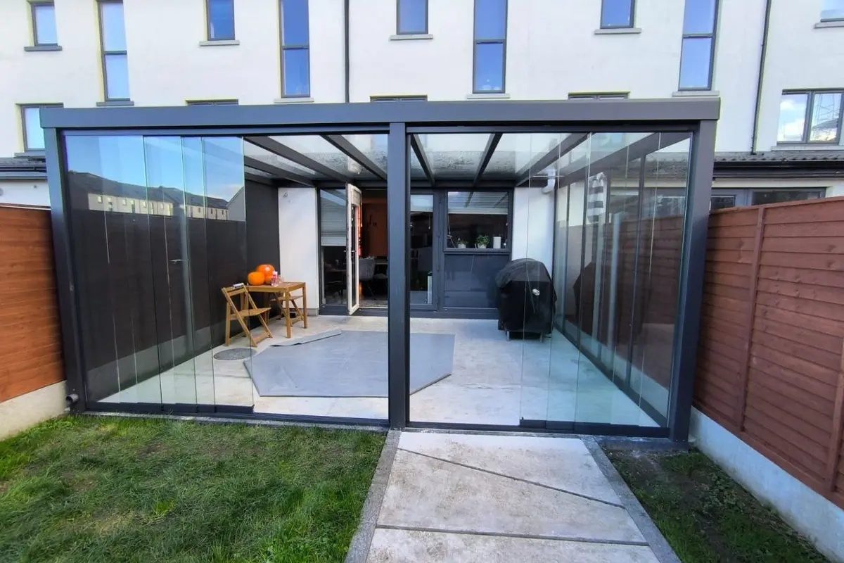 Black wall-mounted glass pergola with sliding glass systems at a Dublin home