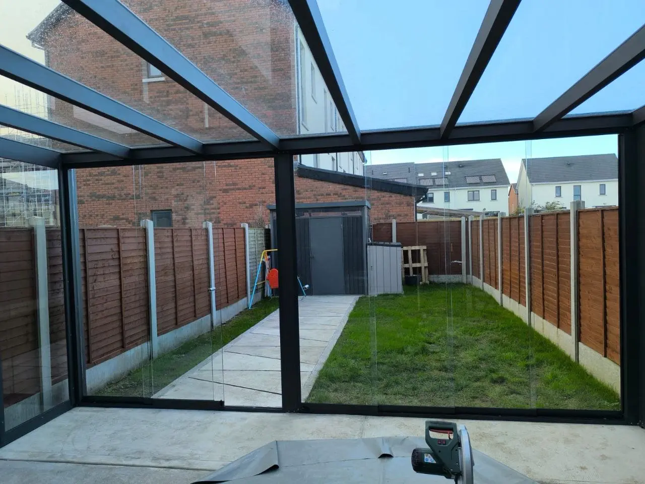 Frameless sliding glass door systems enclosing the front of the Dublin pergola