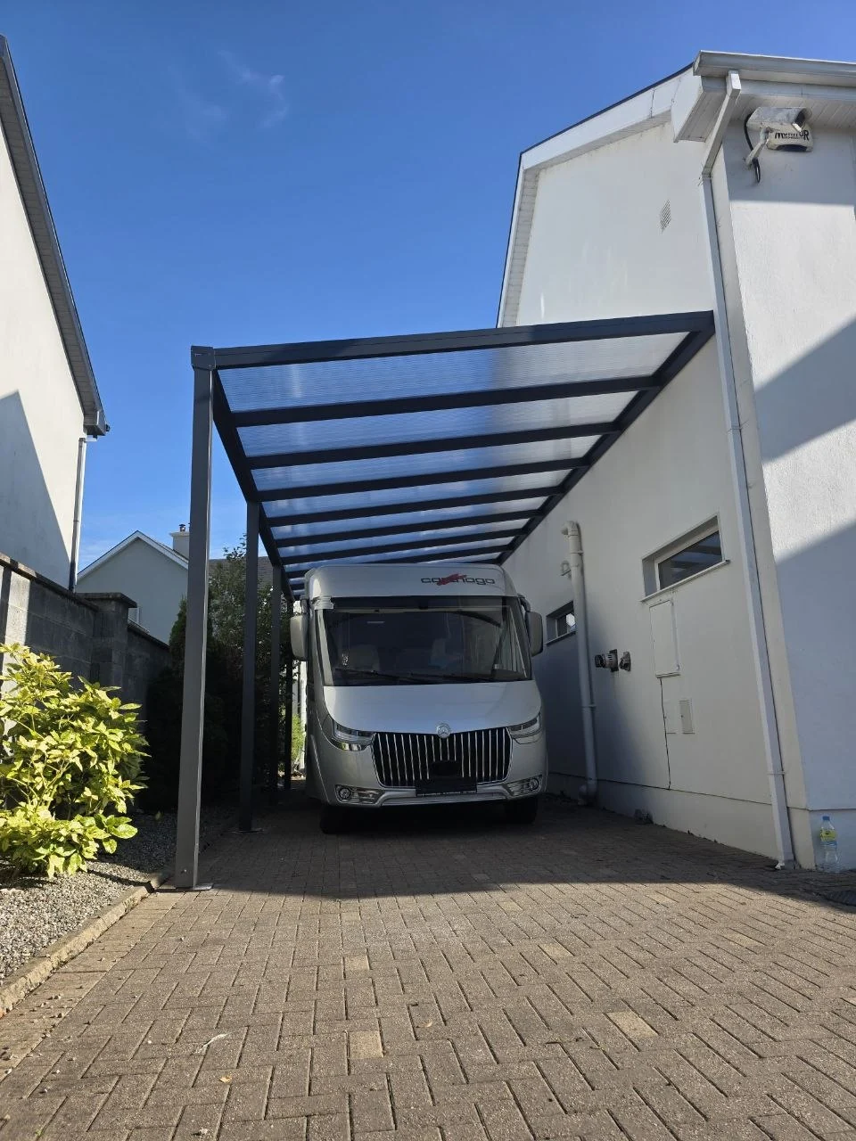Angled view of the high-clearance motorhome carport with transparent polycarbonate roof in Ennis