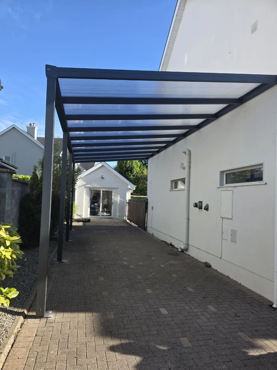 Wide view of the completed wall-mounted motorhome carport beside the home in Ennis, County Clare
