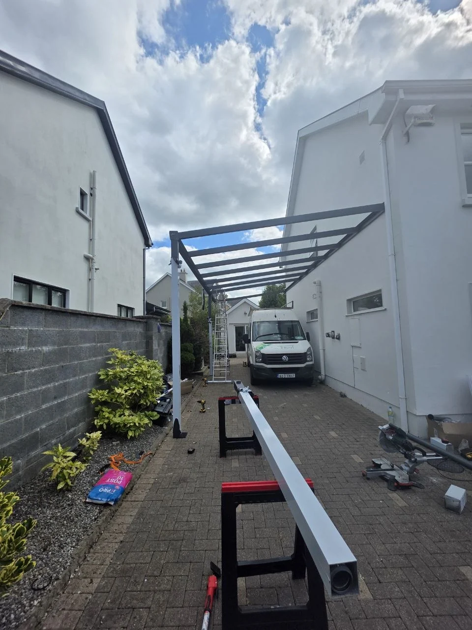Black aluminium motorhome carport frame during installation beside the Ennis home