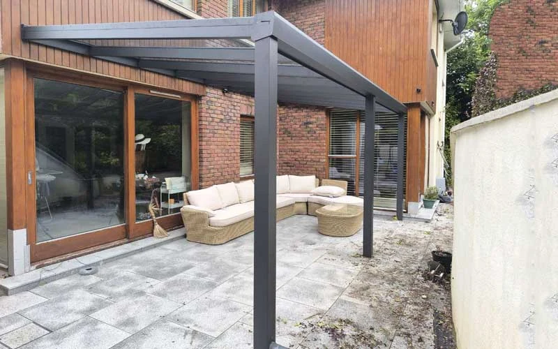 Wall-mounted polycarbonate pergola in a back garden
