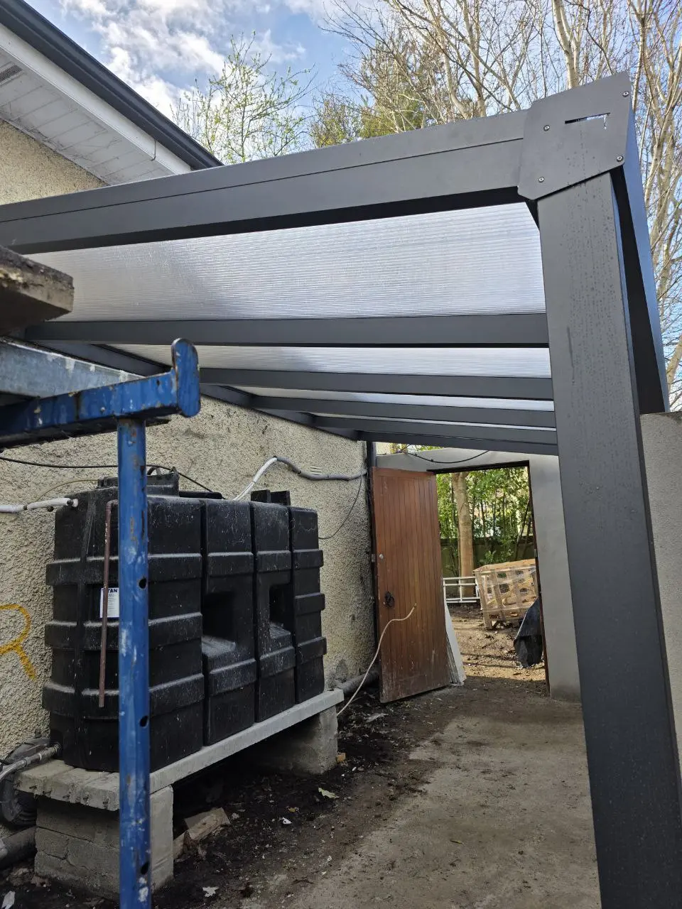 Covered side entrance and heating equipment beneath the polycarbonate canopy