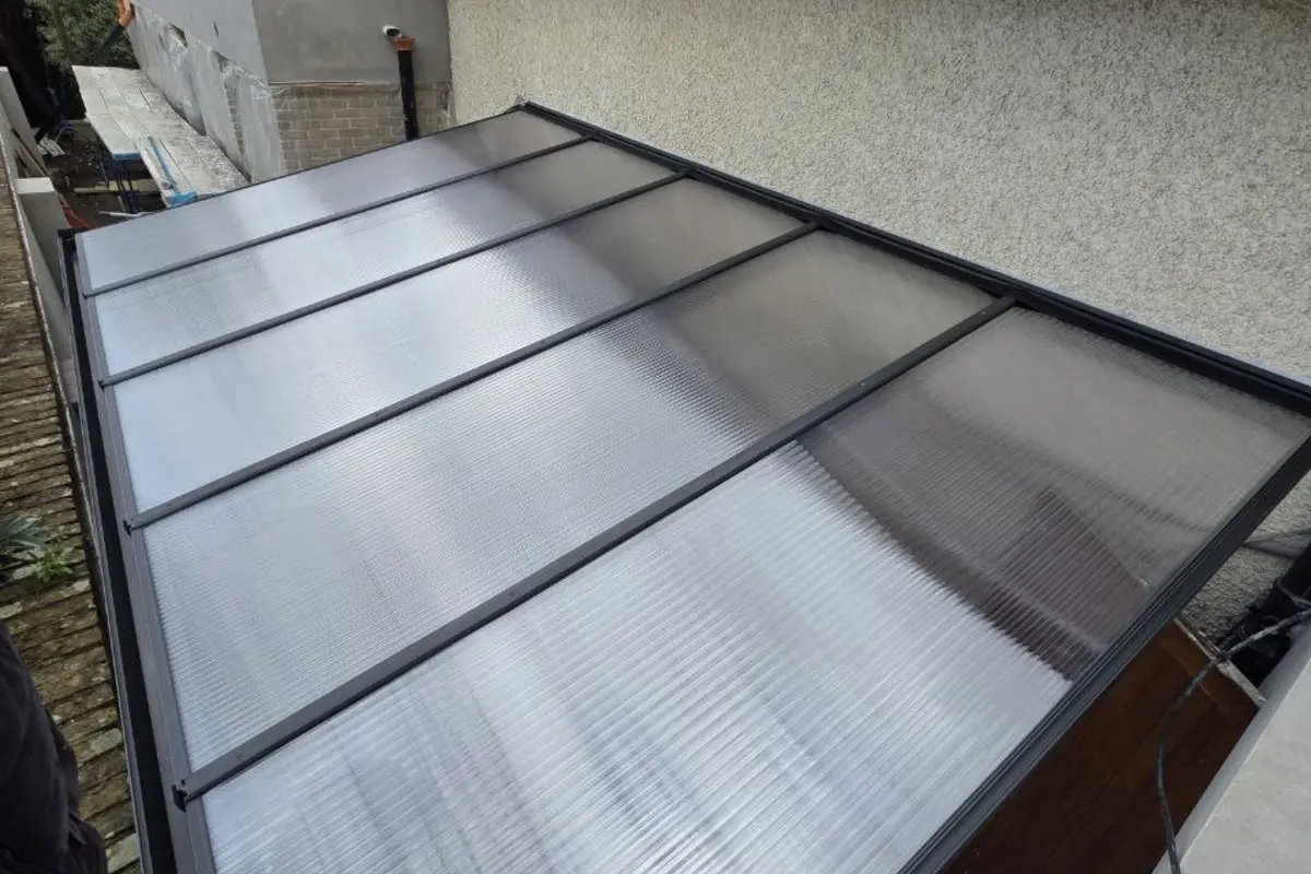 Black wall-mounted aluminium canopy with a clear polycarbonate roof in Dublin